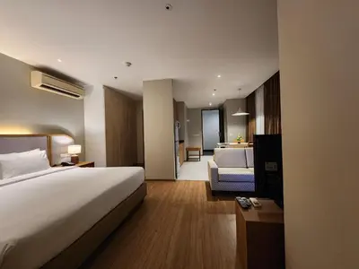a hotel room with a bed and a living room at Brighton Hotel Bangkok in Bangna