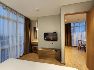 a hotel room with a bed and a flat screen tv at Brighton Hotel Bangkok in Bangna