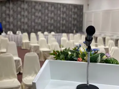 a microphone in front of a room with white chairs at Brighton Hotel Bangkok in Bangna