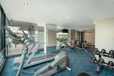 a gym with cardio equipment in a hotel room at VIC 3 Bangkok Hotel in Bangkok