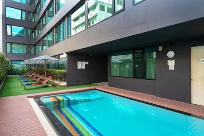 a swimming pool in front of a building at VIC 3 Bangkok Hotel in Bangkok