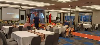 a room with tables and chairs and a man giving a presentation at Witz Bangkok Ramkhamhaeng in Bangkok