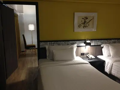 a hotel room with two beds and a desk with a phone at Witz Bangkok Ramkhamhaeng in Bangkok