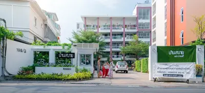 two girls walking down a street in a city at Baan Sabai Rama IV Apartment in Bangkok
