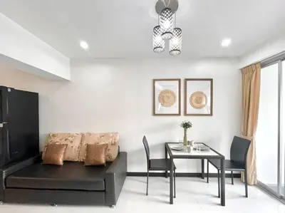 a living room with a couch and a table at Baan Sabai Rama IV Apartment in Bangkok