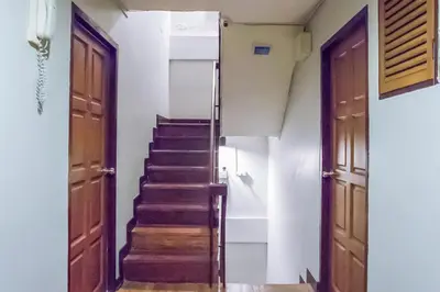 a staircase in a house with wooden doors at Atlas Bangkok Hotel in Bangkok