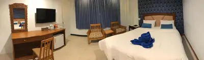 a bedroom with a bed and a desk and a television at At Bangkok Hotel in Bangkok