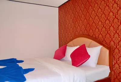 a bedroom with a bed with red and white pillows at At Bangkok Hotel in Bangkok