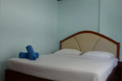 a bedroom with a white bed with a wooden headboard at At Bangkok Hotel in Bangkok