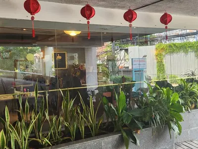 a restaurant with plants in front of a window at Interchange Tower Serviced Apartment - SHA Extra Plus in Bangkok