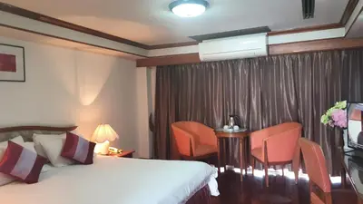 a hotel room with a bed and chairs at Interchange Tower Serviced Apartment - SHA Extra Plus in Bangkok