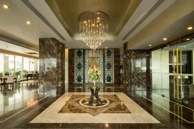 a lobby with a chandelier and a table with flowers at Ivy Thonglor 55 in Bangkok