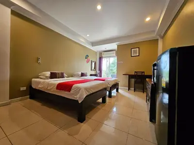a bedroom with two beds and a table in it at Royal Pimand Hotel in Bangkok