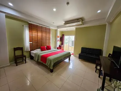 a bedroom with a bed and a couch and a television at Royal Pimand Hotel in Bangkok