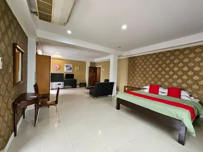 a bedroom with a bed and a desk in a room at Royal Pimand Hotel in Bangkok