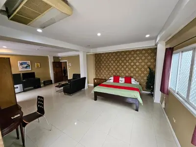 a bedroom with a bed with a red and green blanket at Royal Pimand Hotel in Bangkok