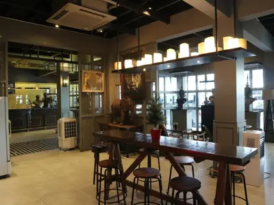 a restaurant with a large wooden table and chairs at Swana Bangkok Hotel in Bangkok