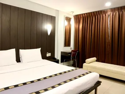 a hotel room with two beds and a desk at Swana Bangkok Hotel in Bangkok