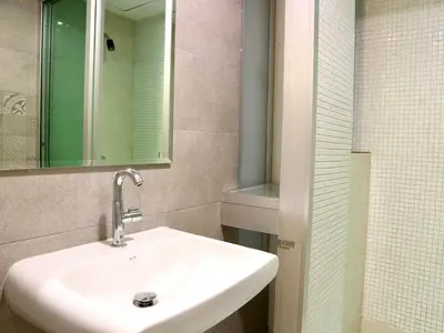 a bathroom with a white sink and a mirror at Swana Bangkok Hotel in Bangkok
