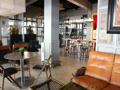 a restaurant with a couch and tables and chairs at Swana Bangkok Hotel in Bangkok