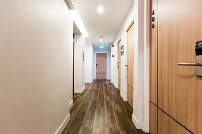 an empty hallway with a door and wooden floors at Metro hotel in Bangkok