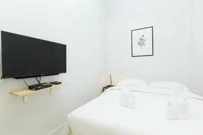 a bedroom with a bed with a flat screen tv at Metro hotel in Bangkok