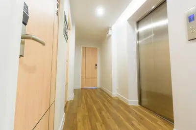 a hallway with a door leading to a room with wooden floors at Metro hotel in Bangkok