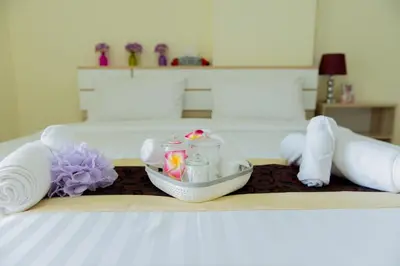 a bed with a tray with candles and towels at Be My Guest 36 in Bangkok