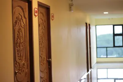 a hallway with a wooden door and a window at Be My Guest 36 in Bangkok