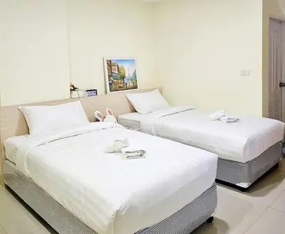two beds in a hotel room with white sheets at Be My Guest 36 in Bangkok