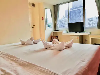 a bedroom with a bed with white pillows on it at The Konnect Hotel in Bangkok