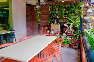 a table and chairs in a restaurant with plants at The Konnect Hotel in Bangkok
