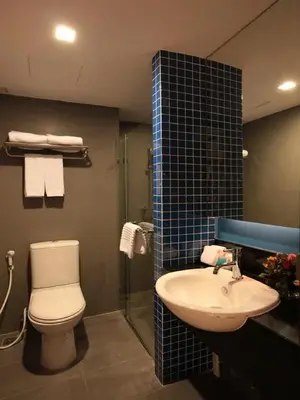 a bathroom with a toilet and a sink at FX Hotel Metrolink Makkasan in Bangkok