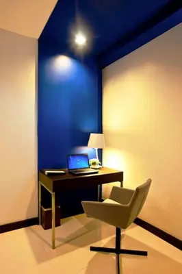 a desk with a laptop and a chair in a room at FX Hotel Metrolink Makkasan in Bangkok