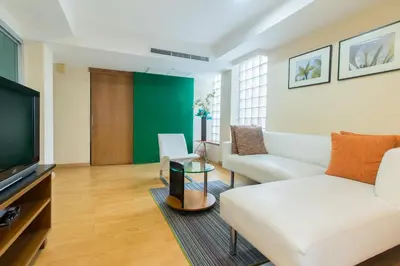 a living room with a couch and a tv at Silom Convent Garden in Bangkok
