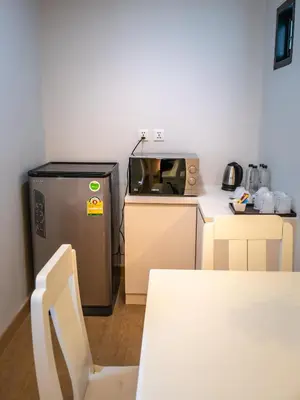 a small kitchen with a microwave and a refrigerator at The Kinn Bangkok in Bangkok