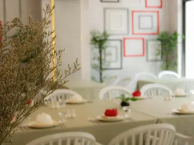 a dining room with white tables and white chairs at The Kinn Bangkok in Bangkok
