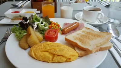 a white plate of breakfast food with eggs and toast at The Kinn Bangkok in Bangkok