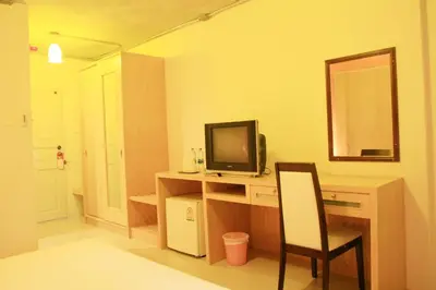a room with a desk with a tv and a chair at Bansabai Sabaidee Service Apartment in Bangkok