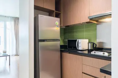 a kitchen with a refrigerator and a microwave at Bangkok Patio BTS Sanam Pao in Bangkok