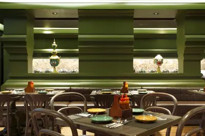 a dining room with tables and chairs and windows at Chillax Heritage Hotel Khaosan in Bangkok