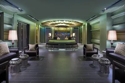 a lobby with couches and a bar in the middle at Chillax Heritage Hotel Khaosan in Bangkok