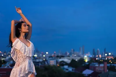 a woman in a white dress with her hand in the air at Chillax Heritage Hotel Khaosan in Bangkok