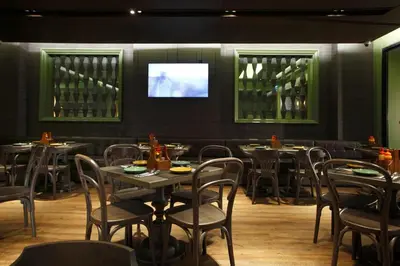a dining room with tables and chairs and a television at Chillax Heritage Hotel Khaosan in Bangkok