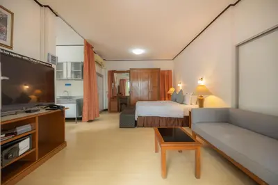 a hotel room with a bed and a couch at Bangkok Rama Hotel in Bangkok