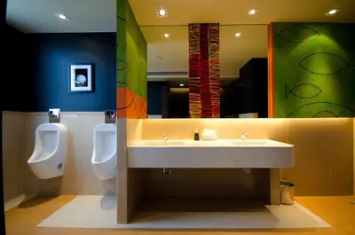 a bathroom with two urinals and a sink and two toilets at Tongtara Riverview Hotel in Bangkok