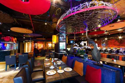 a restaurant with tables and chairs and a bar at Tongtara Riverview Hotel in Bangkok
