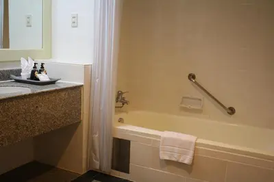 a bathroom with a bath tub and a sink at Tongtara Riverview Hotel in Bangkok