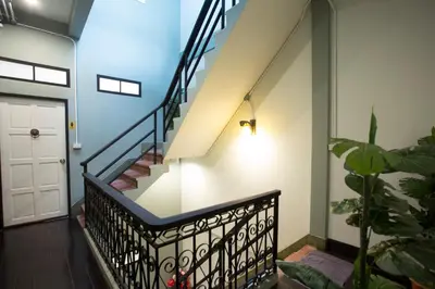 a staircase in a house with a white door at The Orientale Hostel in Bangkok