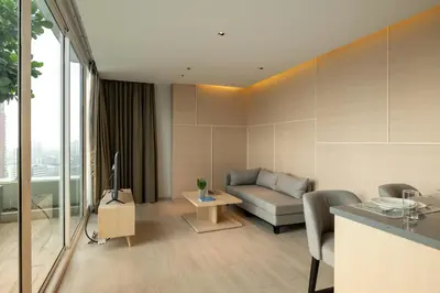a living room with a couch and a television at Jasmine 59 Hotel in Bangkok